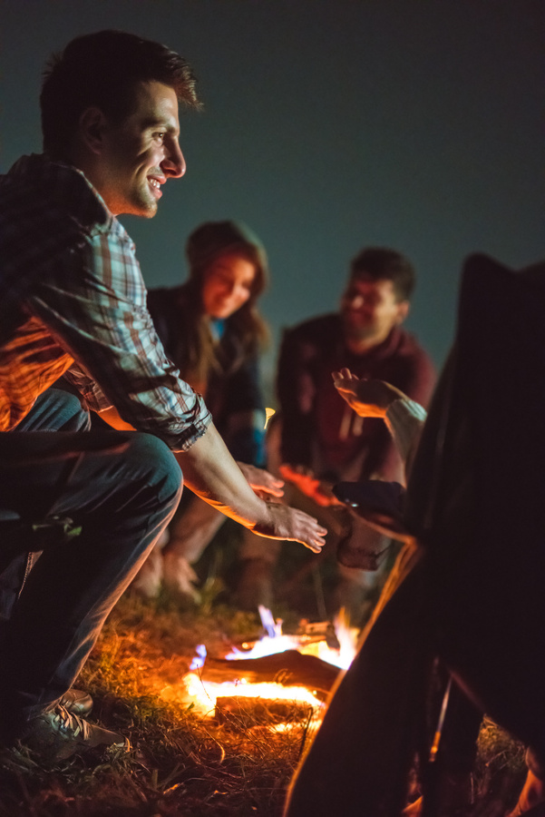 The smile people warming hands near the bonfire. night time